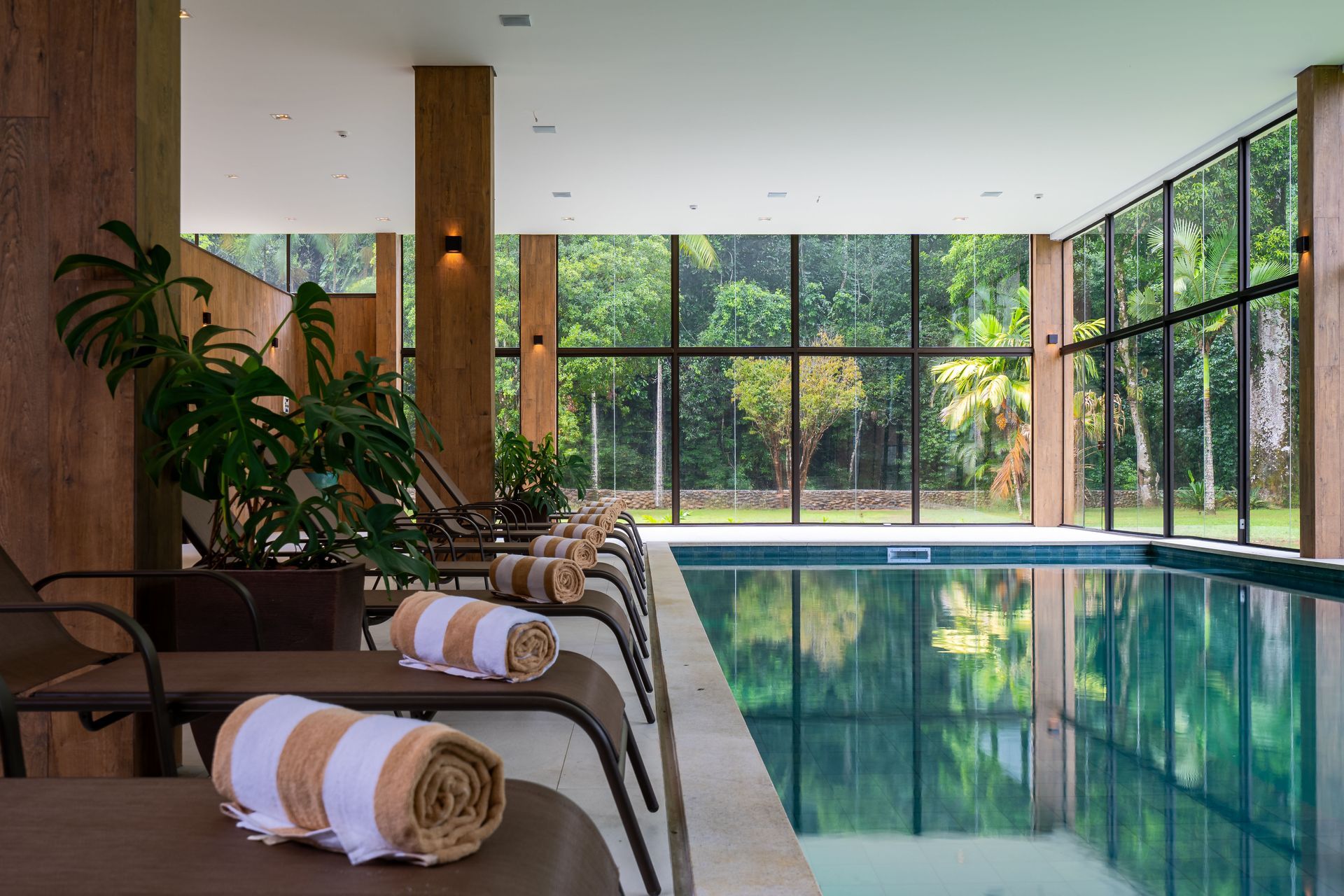 Uma grande piscina coberta cercada por cadeiras e toalhas.