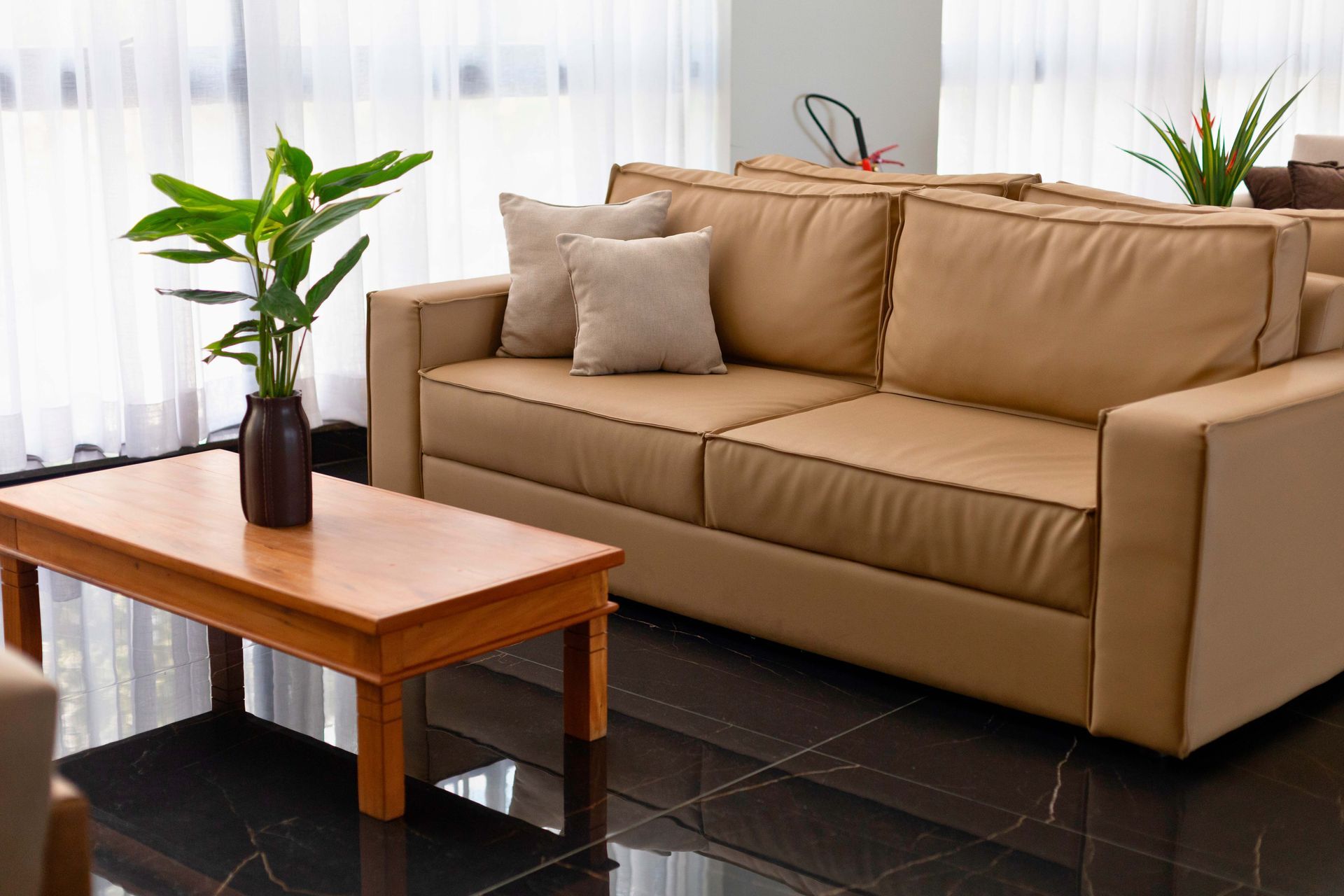 Uma sala de estar com um sofá, mesa de centro e planta.