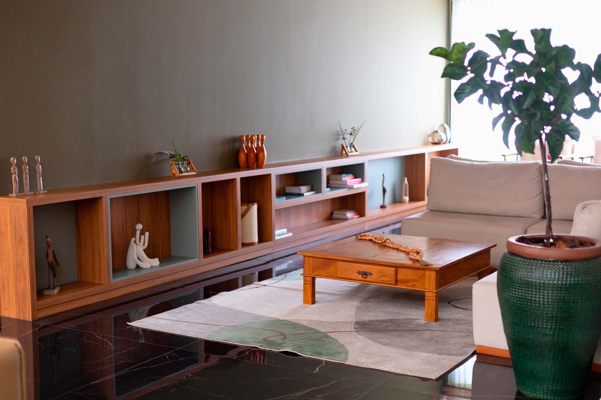 Uma sala de estar com um sofá, uma mesa de centro e uma planta em vaso.