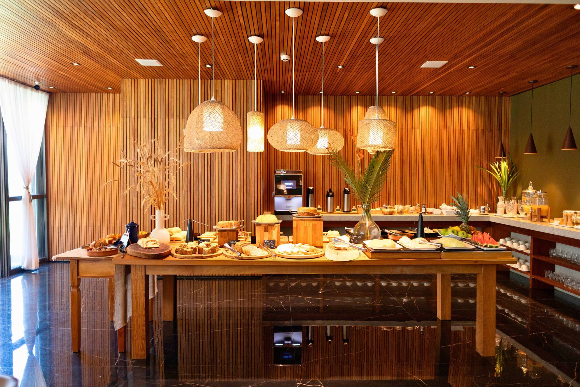 Uma sala grande com teto de madeira e mesa de bufê