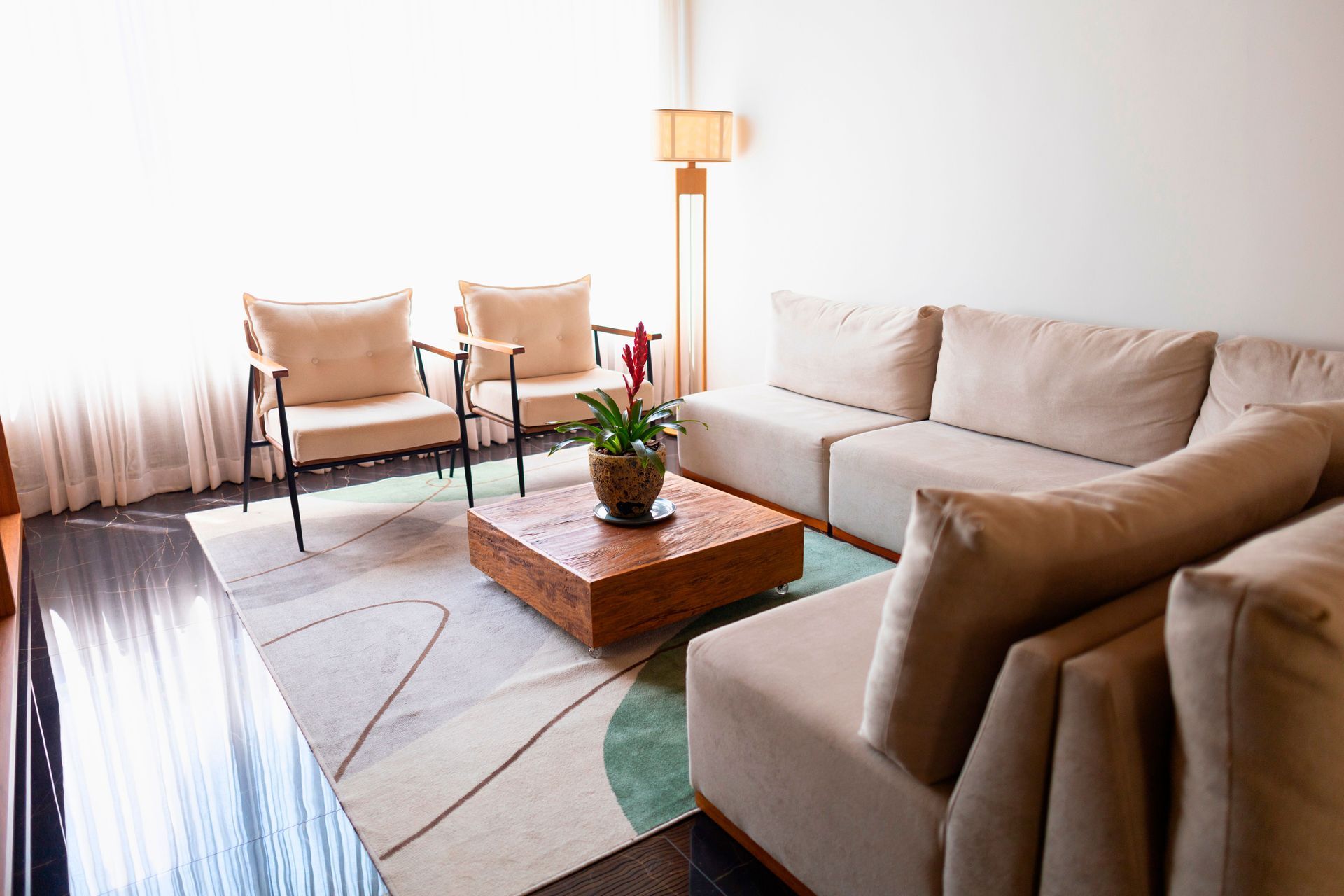 Uma sala de estar com um sofá, cadeiras e uma mesa de centro