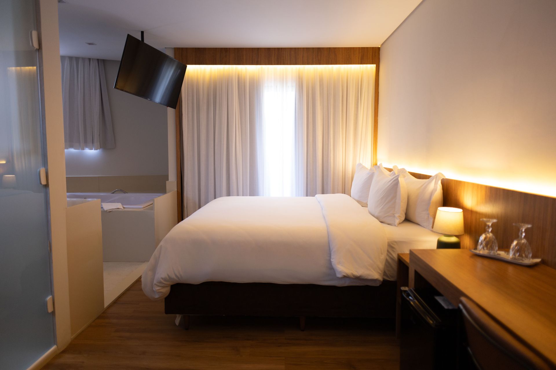 Um quarto de hotel com uma cama king size e uma TV de tela plana.