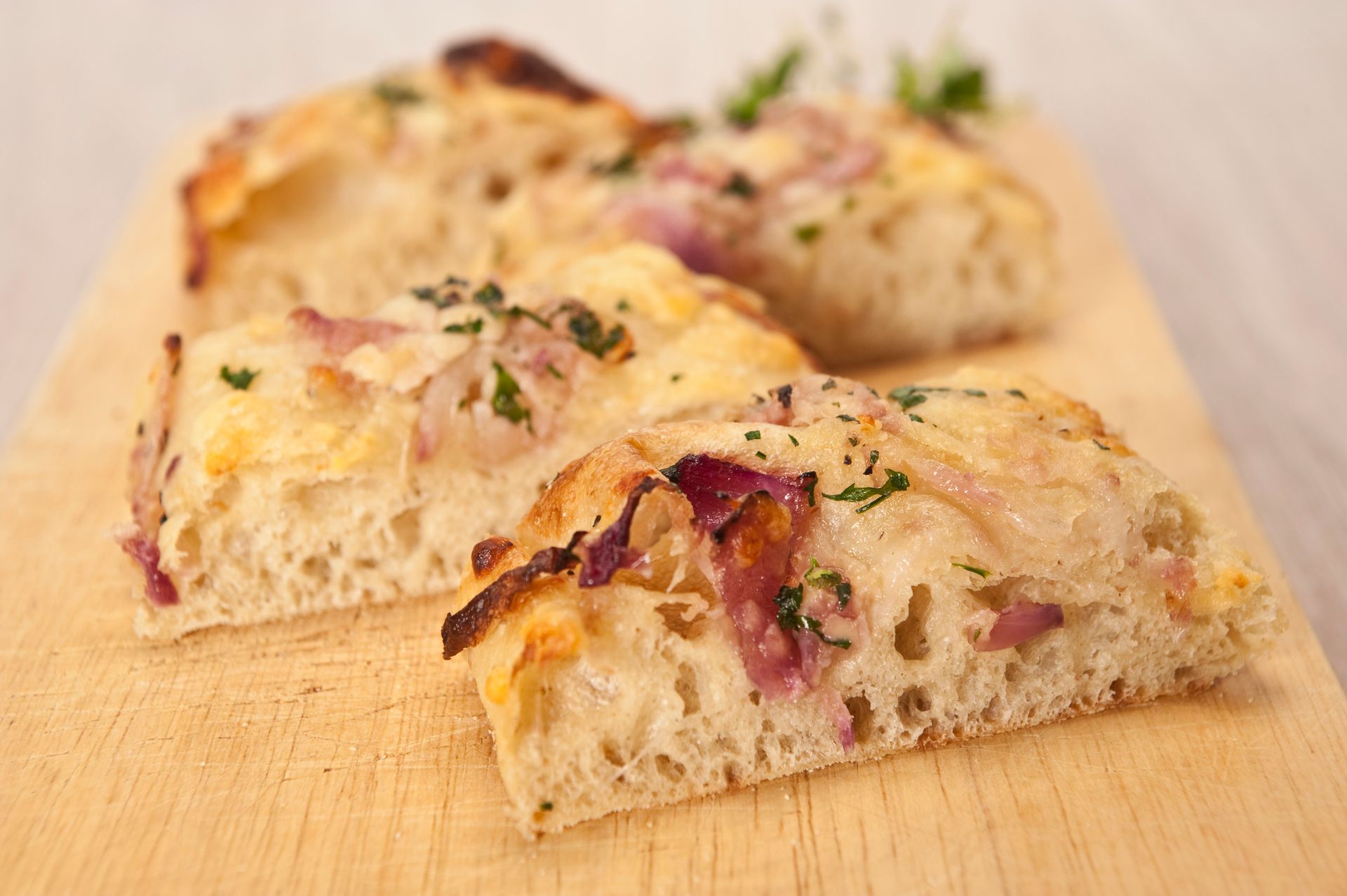 Una fetta di pizza è appoggiata su un tagliere di legno.