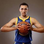 A basketball player in a blue and yellow jersey holding a basketball.