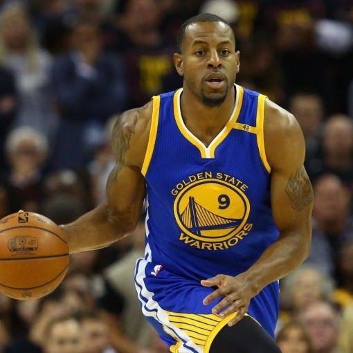 Basketball player Andre Iguodala dribbling the ball in a Golden State Warriors jersey.