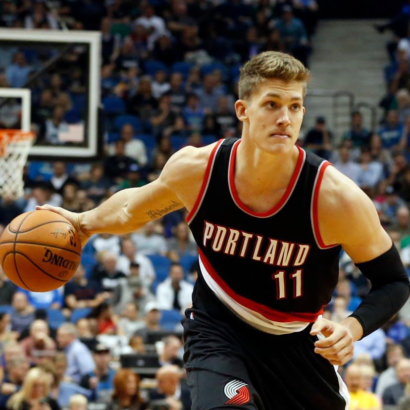 Basketball player in a black Portland jersey dribbling the ball on a court.