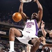 Basketball player dunking, leaping towards the hoop, jersey number 55.