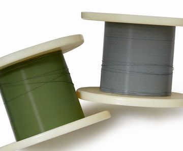 Two spools of wire are sitting next to each other on a white surface  rothgreaves ptfe coatings