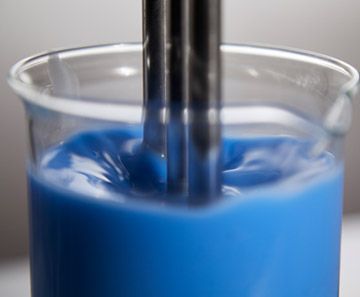 A close up of a beaker filled with blue liquid.  rothgreaves ptfe coatings