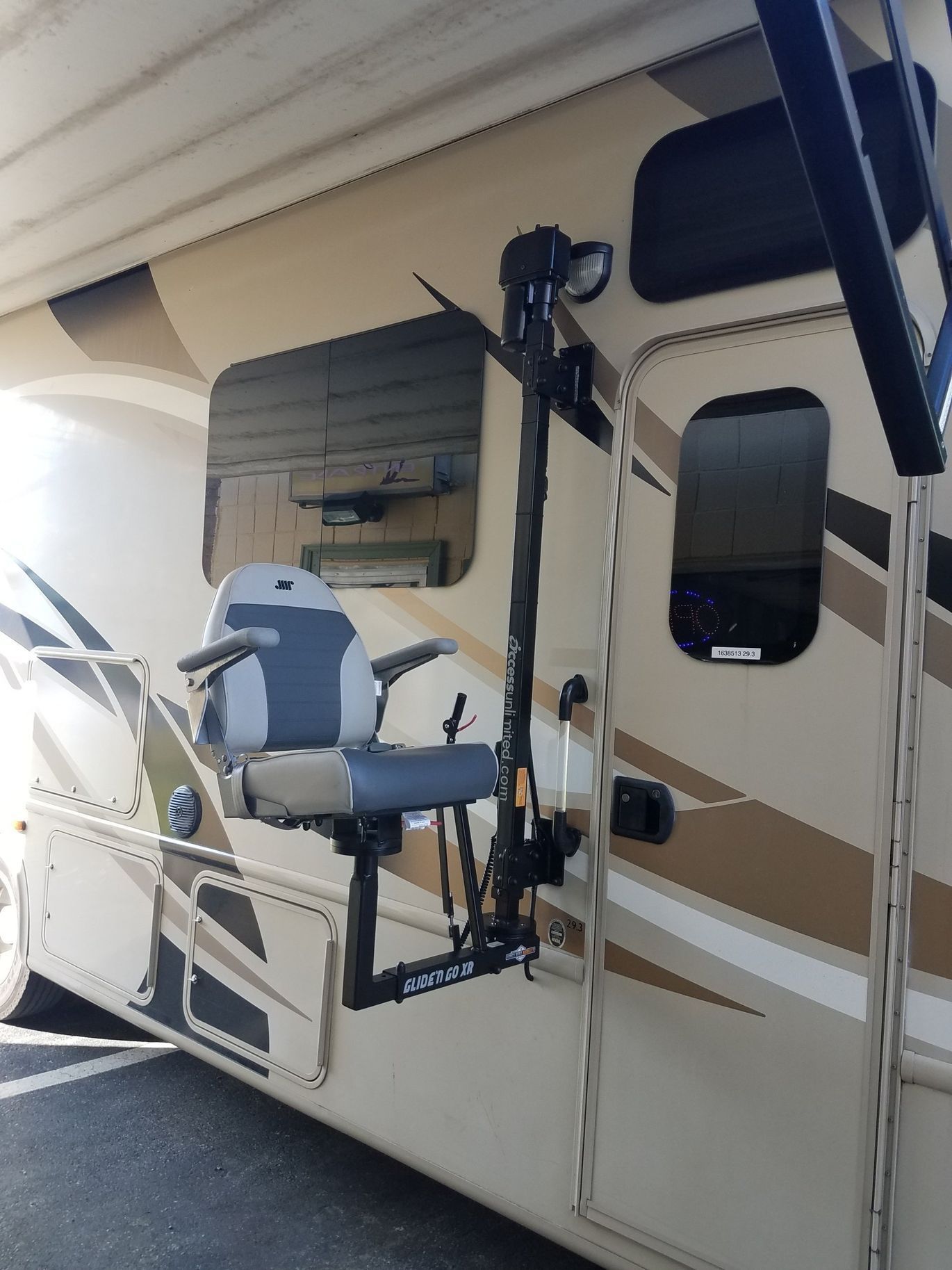 A rv with a chair attached to the side of it