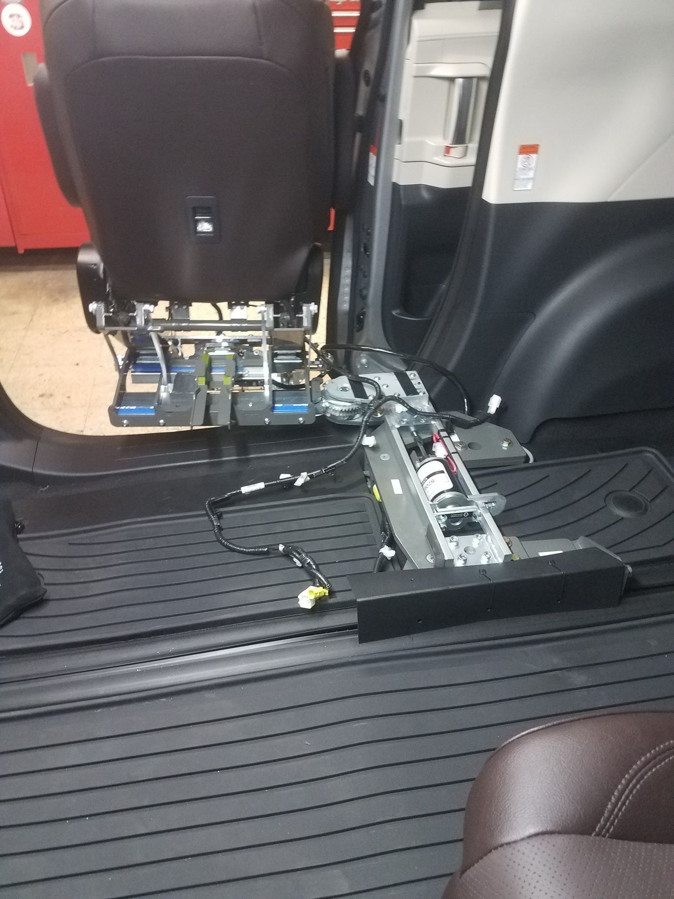 The back seat of a car is being removed to make room for a wheelchair.