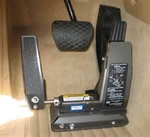 A close up of a brake pedal and a foot pedal on a table.