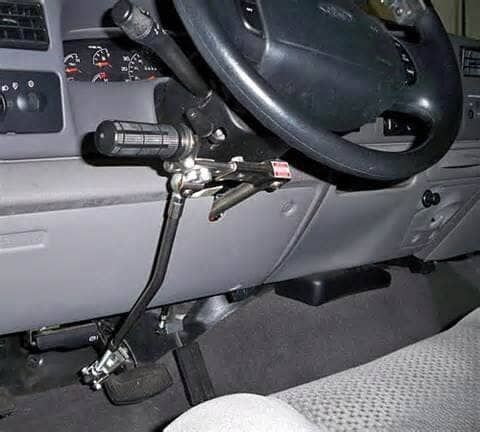 A close up of a car dashboard with a steering wheel and a foot pedal.
