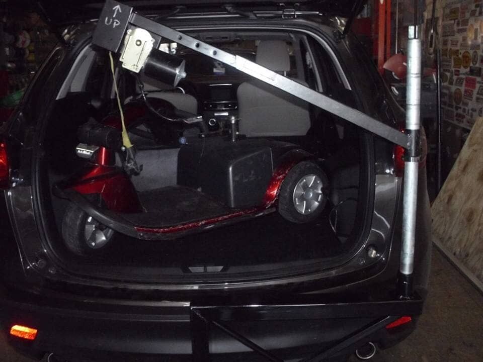 A mobility scooter is sitting in the back of a car