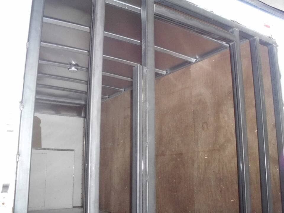 The inside of a truck with a metal frame and wooden walls