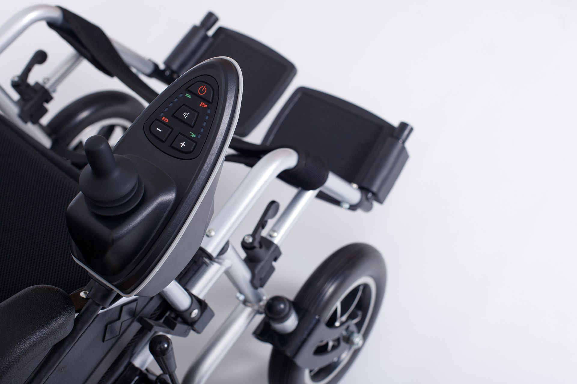A Close Up of an Electric Wheelchair With a Remote Control