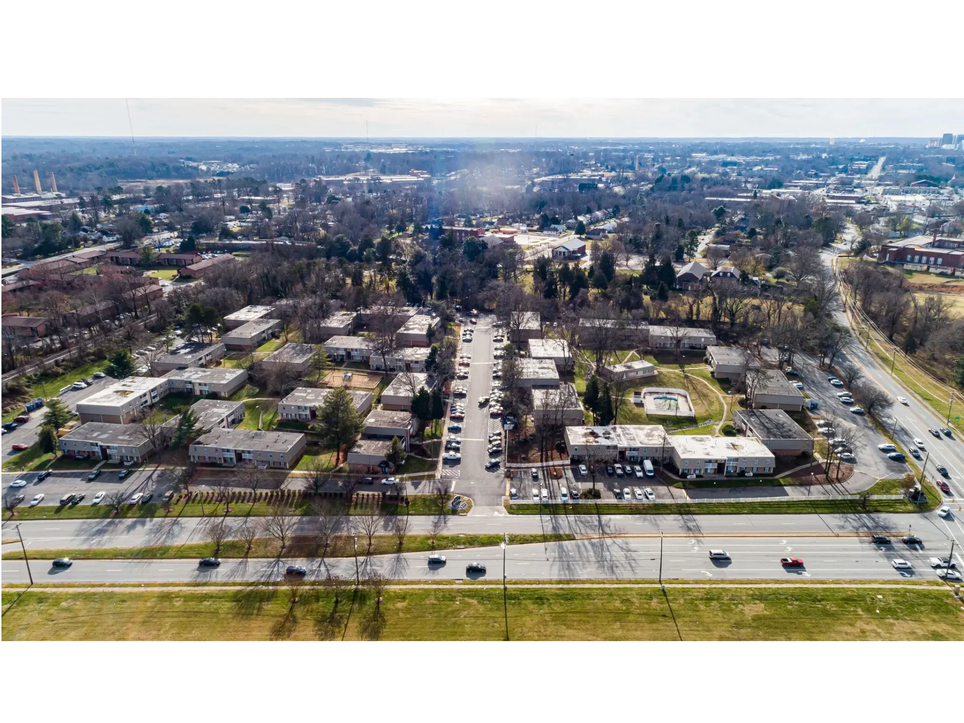 Aerial view of a multi-building apartment community with parking lots and surrounding streets.