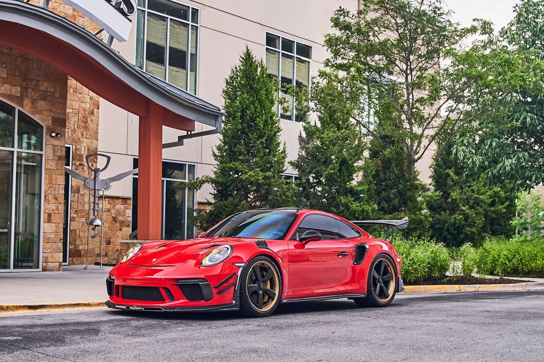 A red sports car is parked in front of a building.