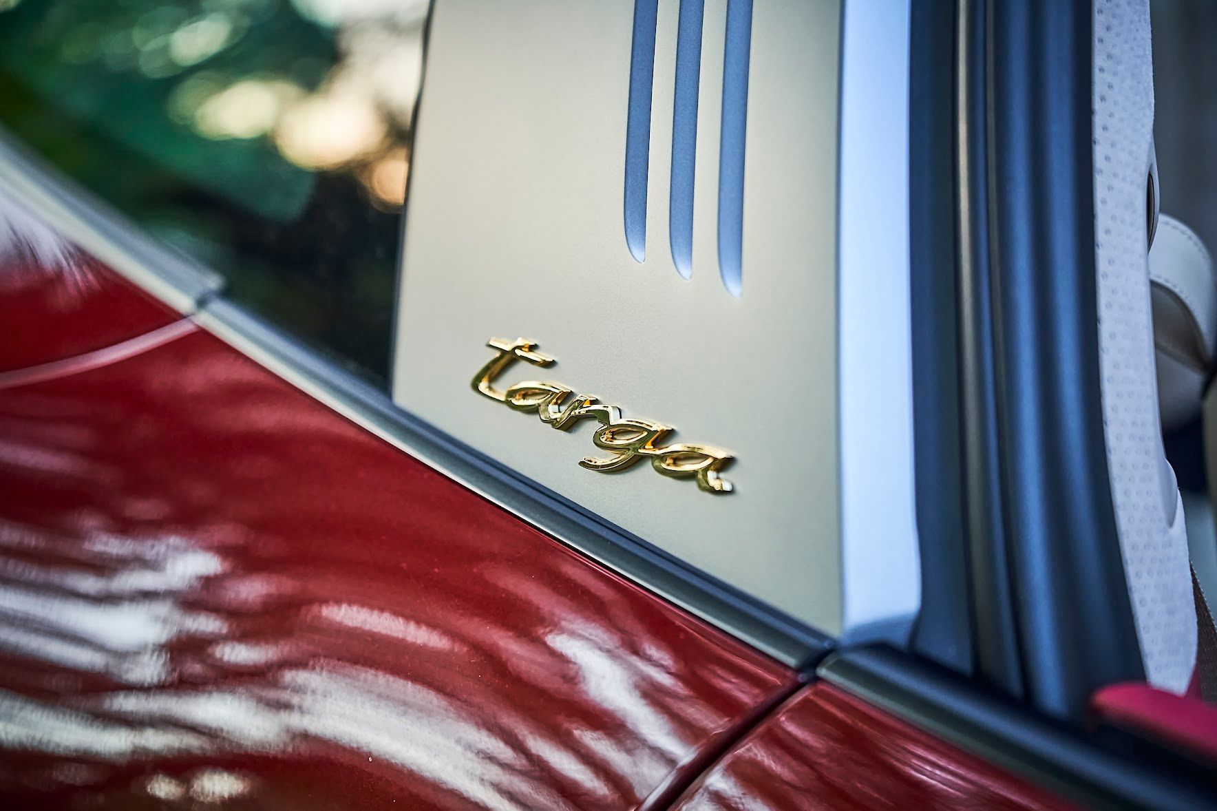 A close up of the side of a red car with the word targa on it