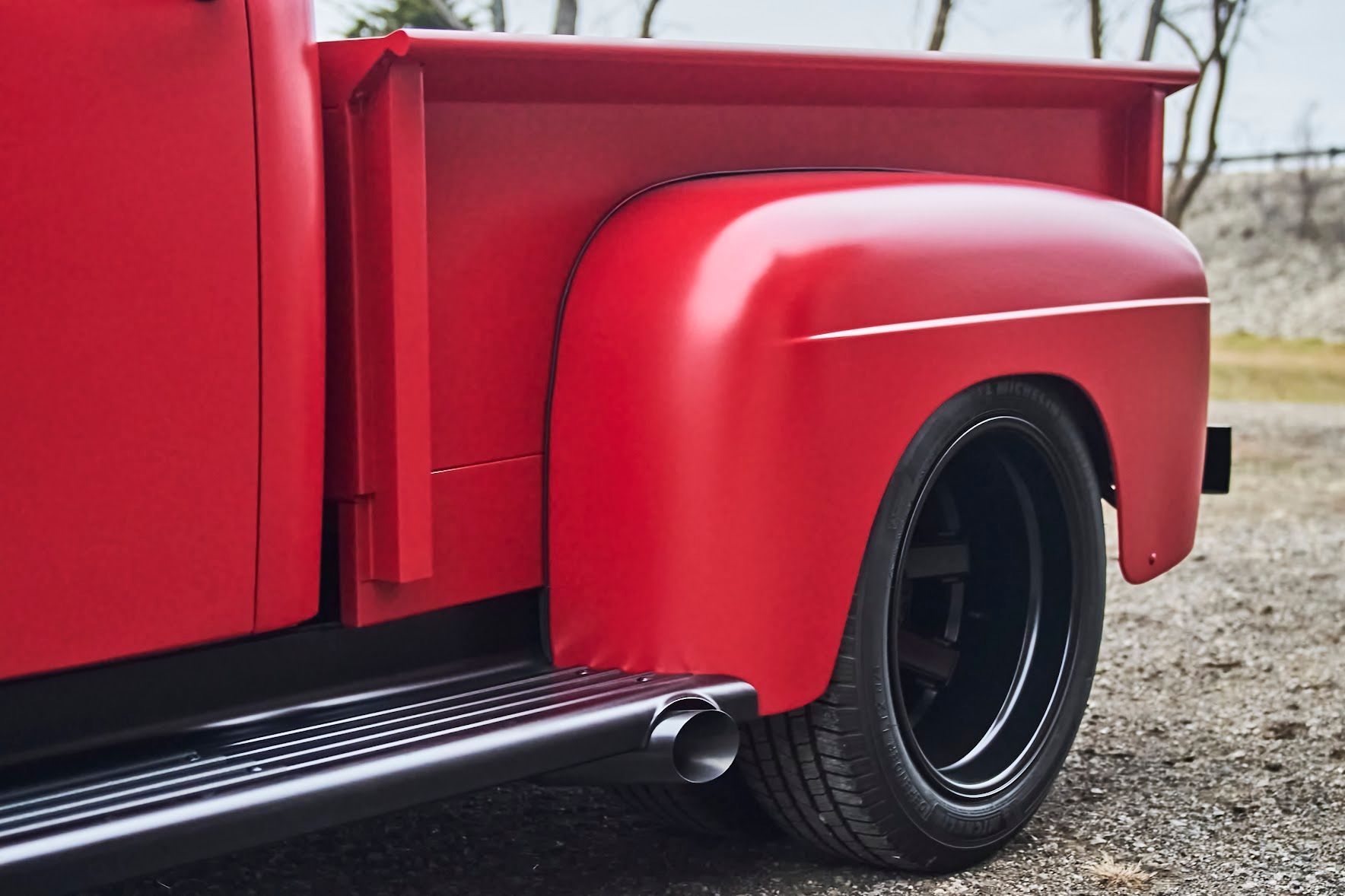 A red truck is parked on the side of the road.