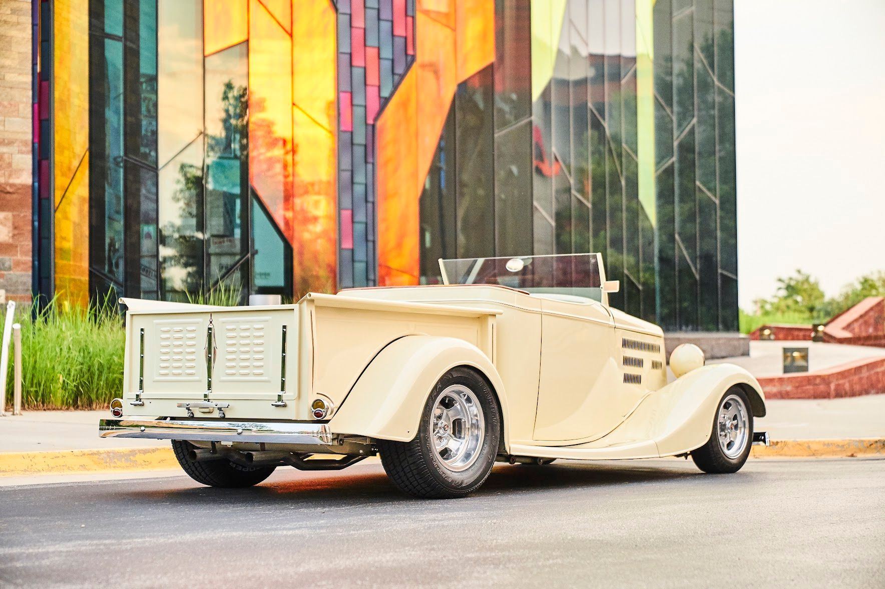 A white car is parked in front of a stained glass building.
