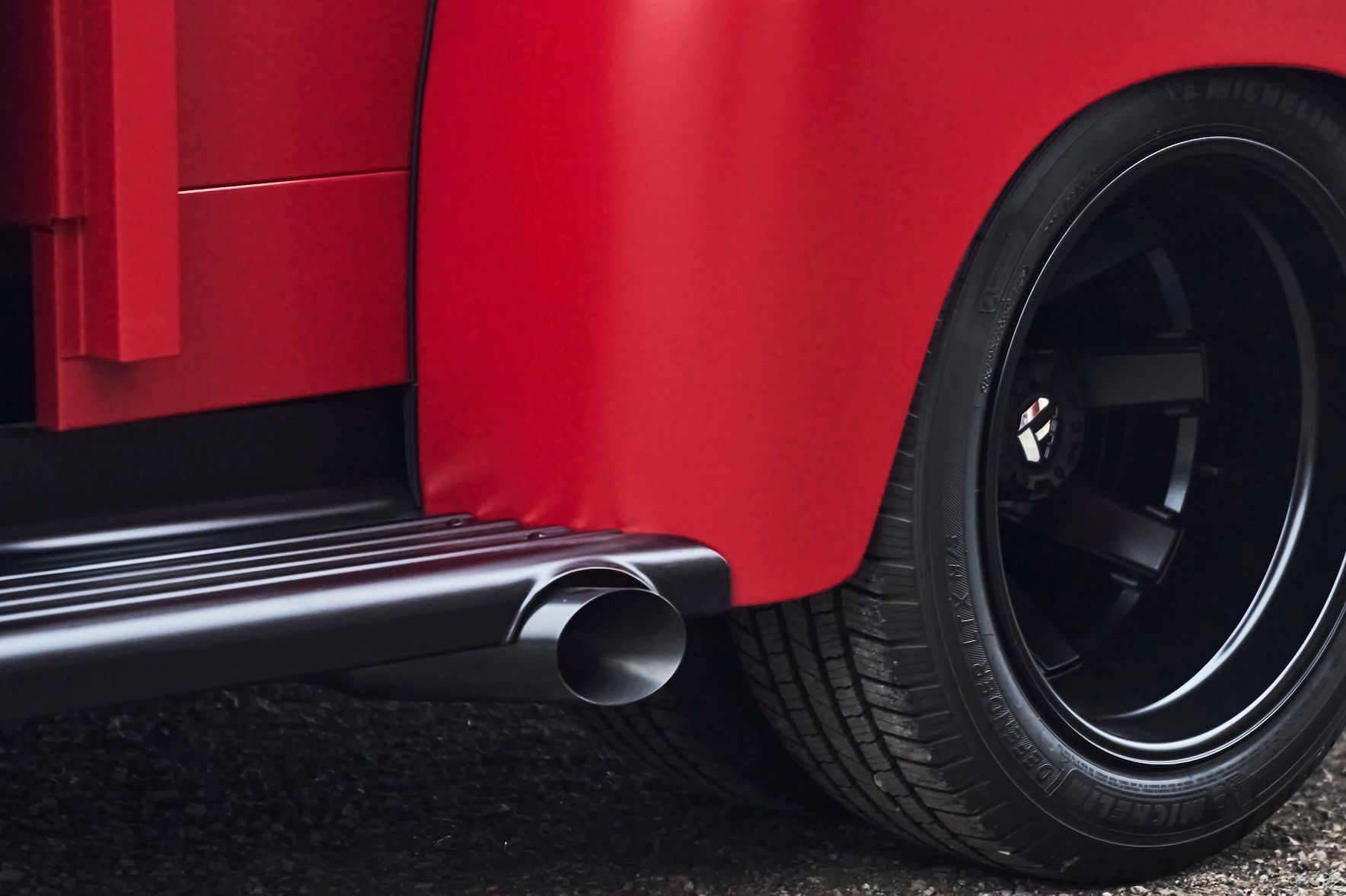 A red truck with black wheels and a black exhaust pipe