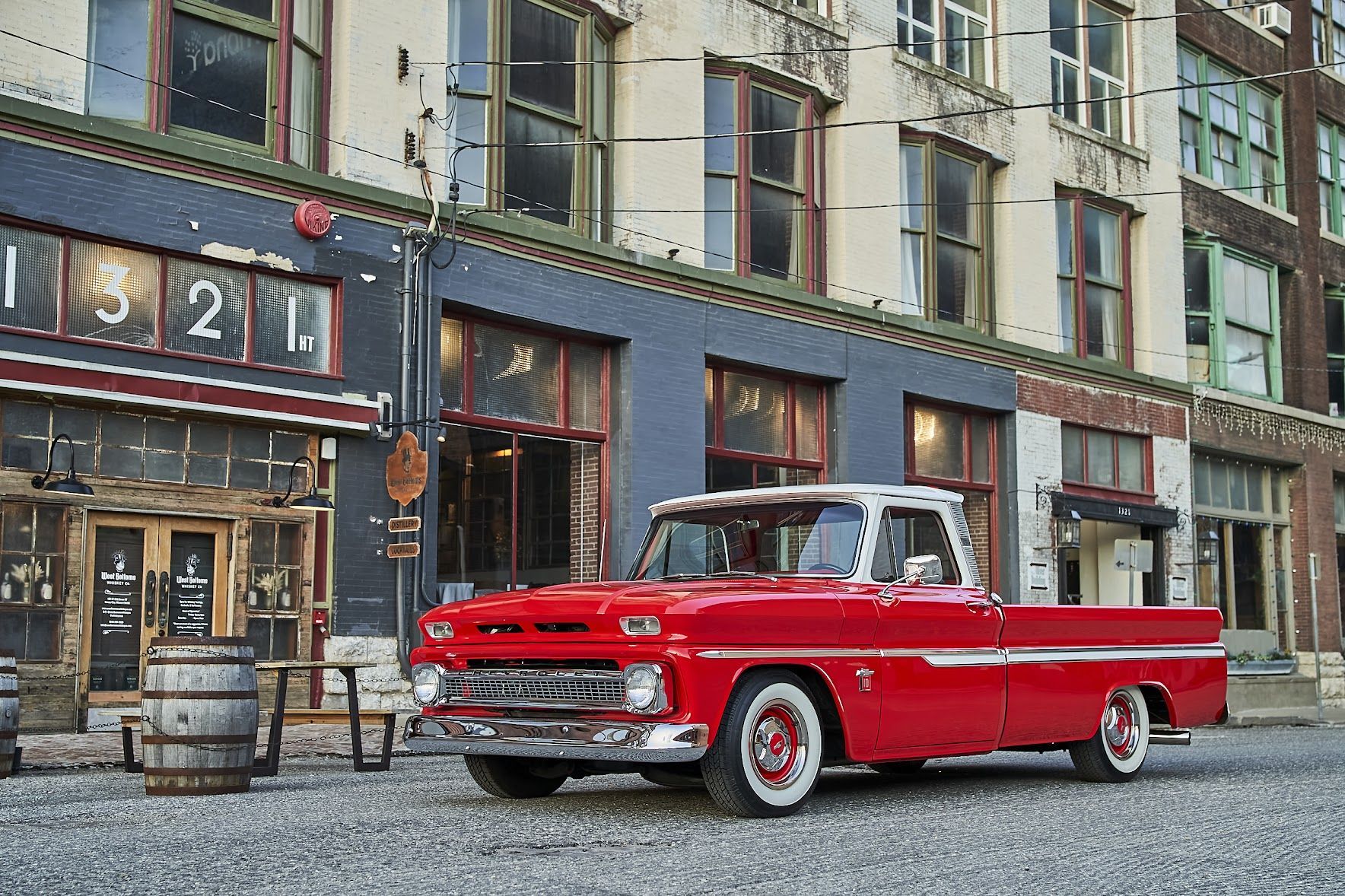A red pickup truck is parked in front of a building.
