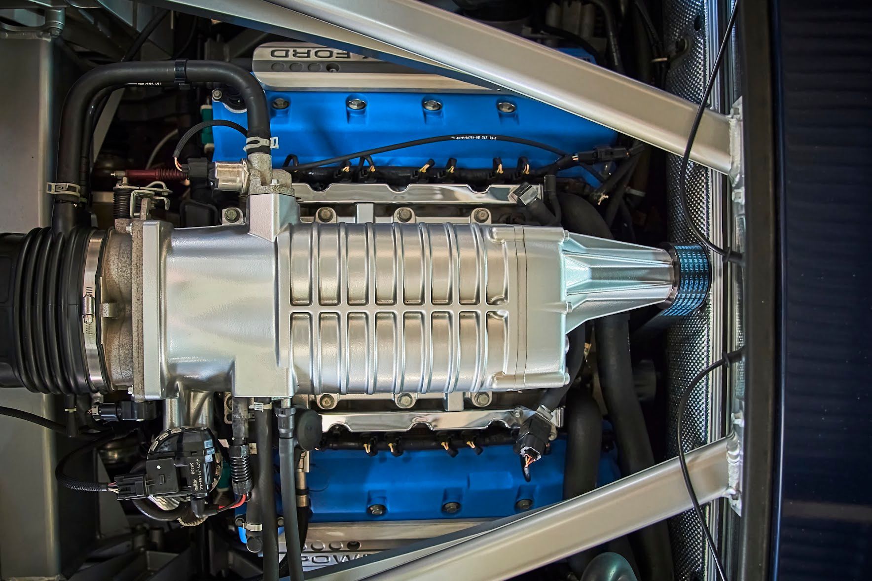 A close up of a car engine with blue valve covers