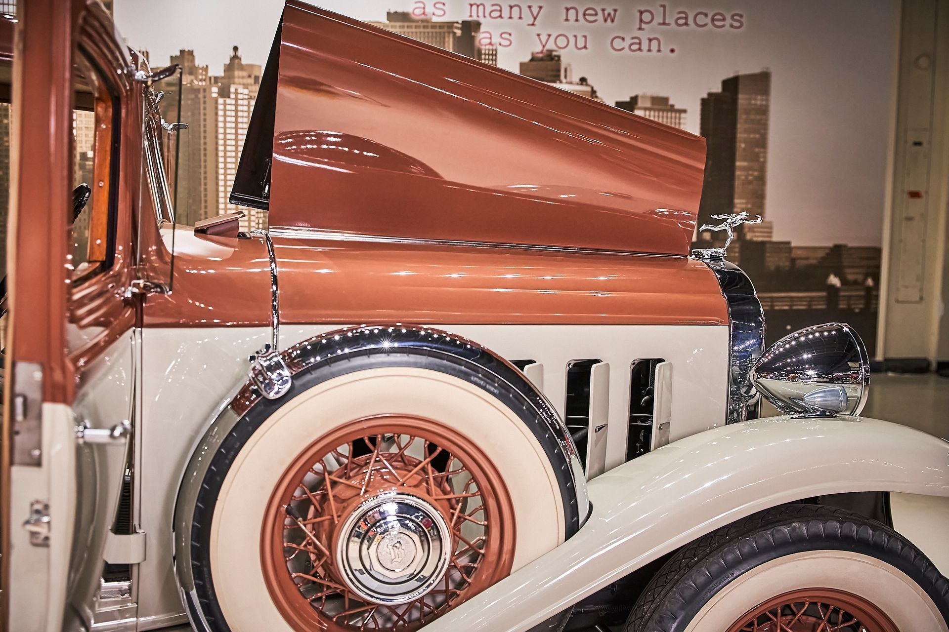 An old car with the hood up and a quote that says many new places as you can