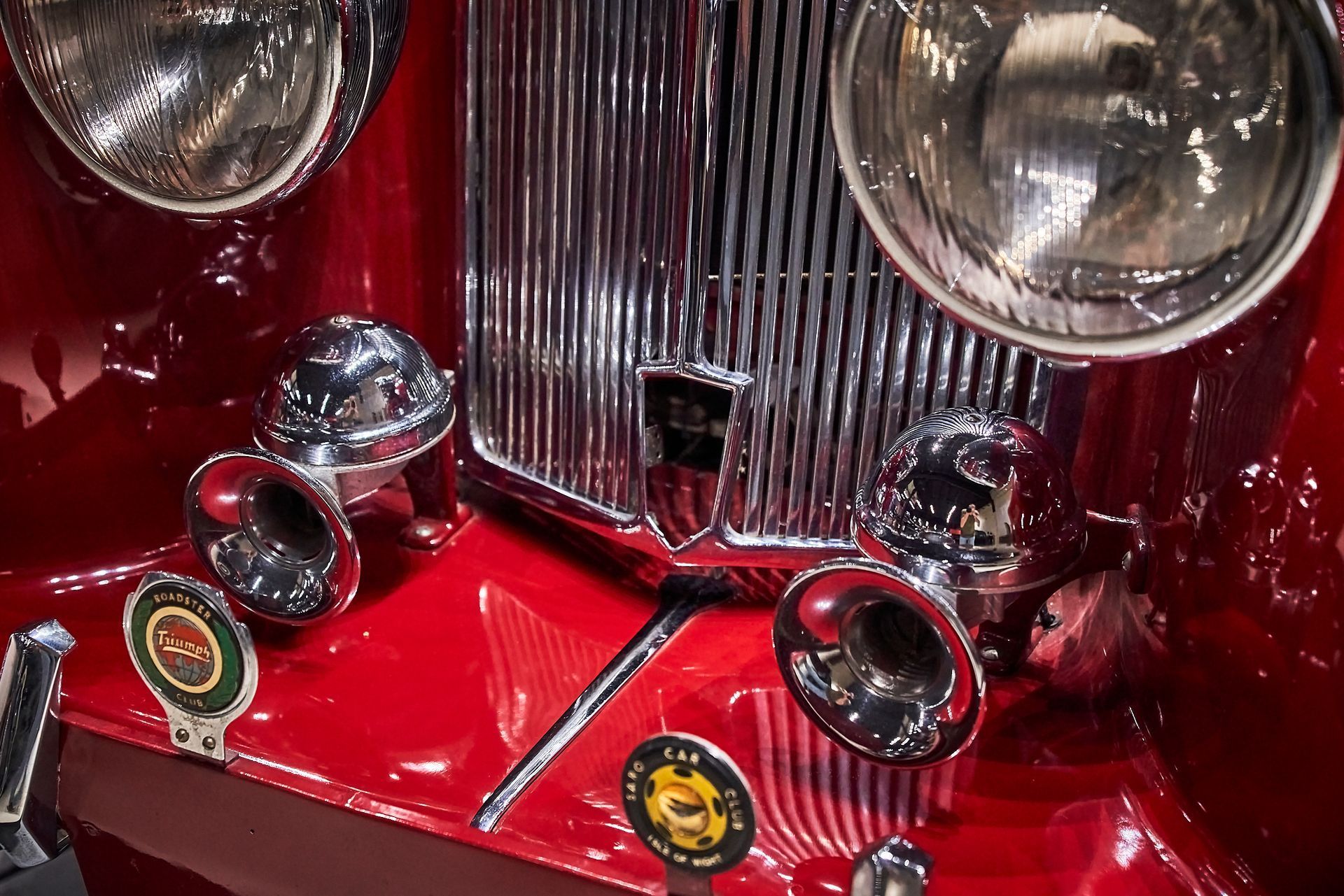 A close up of a red car with horns and headlights