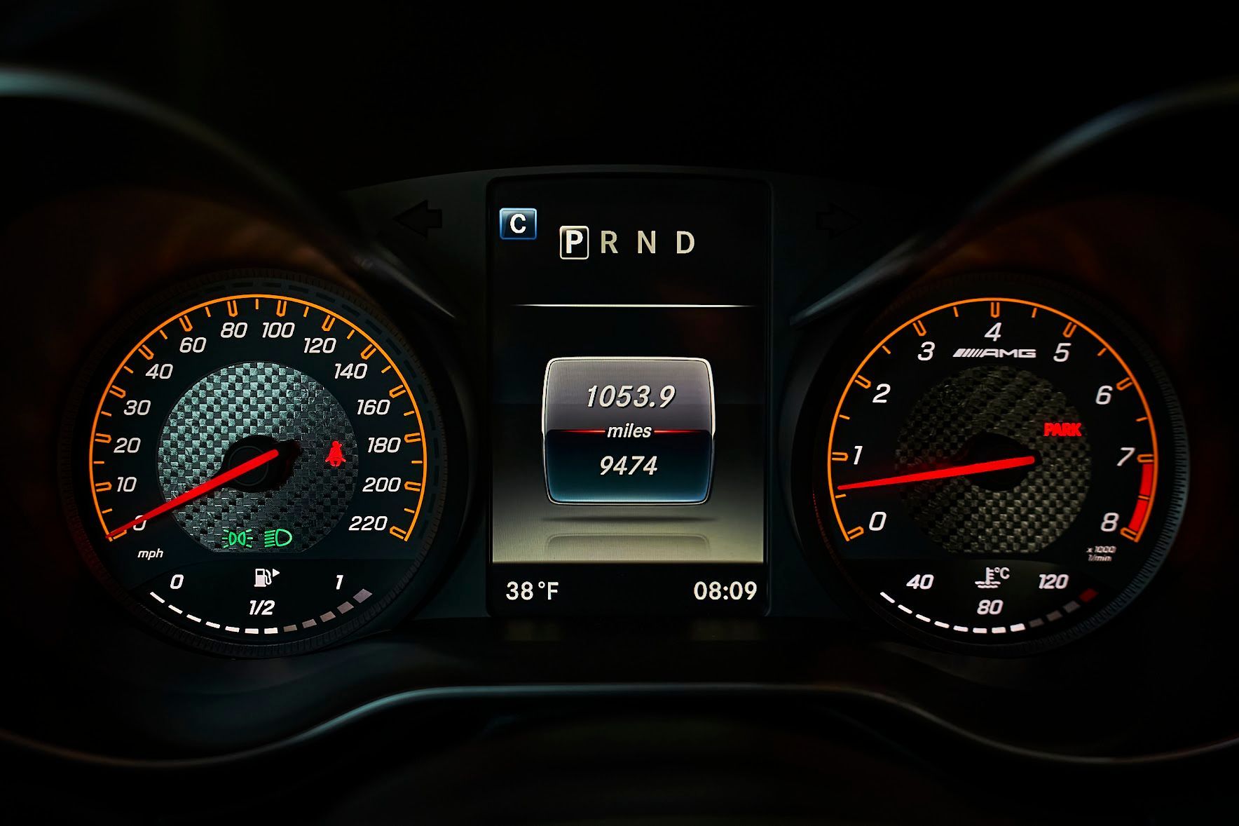 A close up of a car dashboard with a speedometer and a tachometer