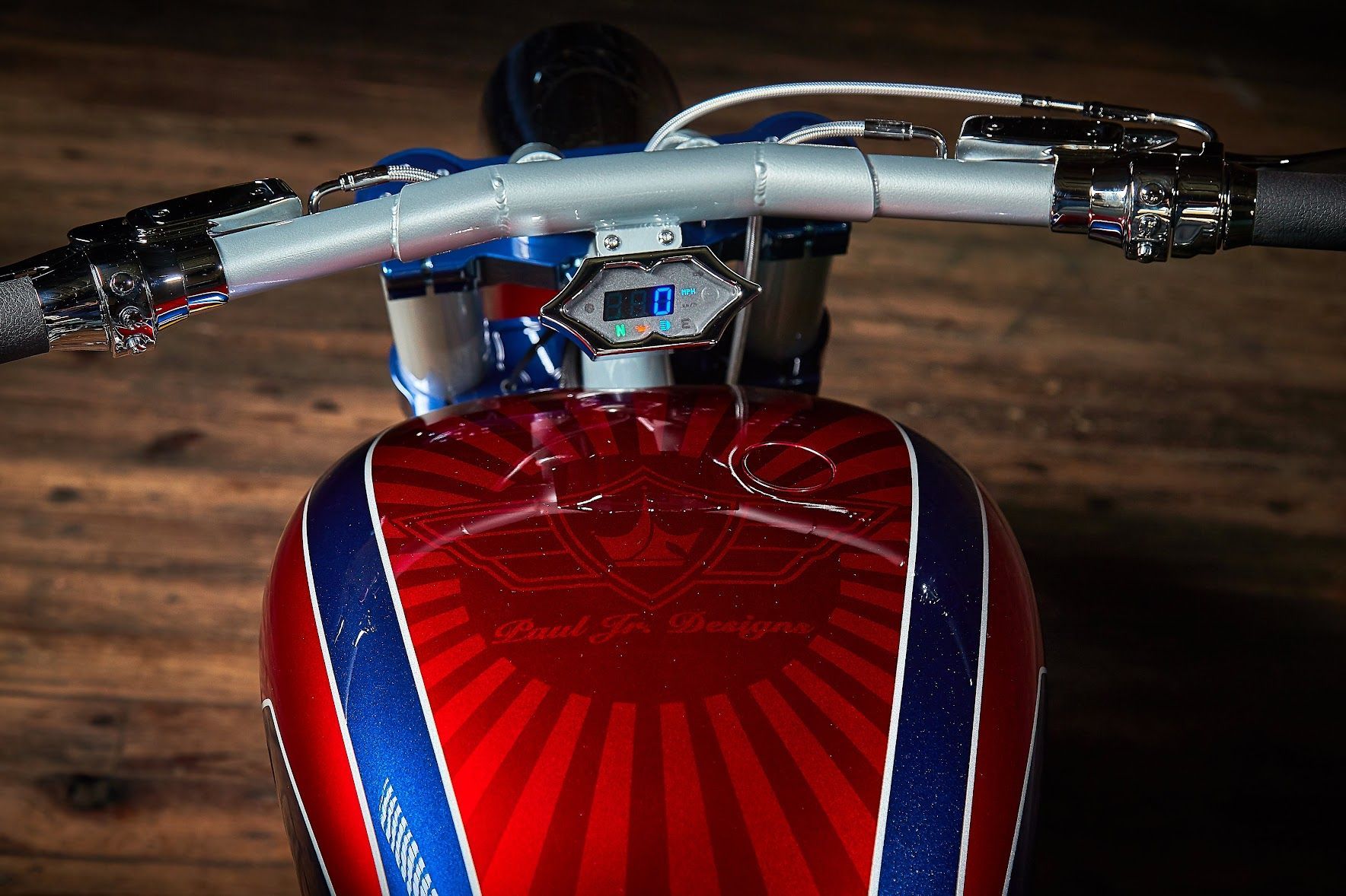 A red motorcycle with a blue and white stripe on the tank