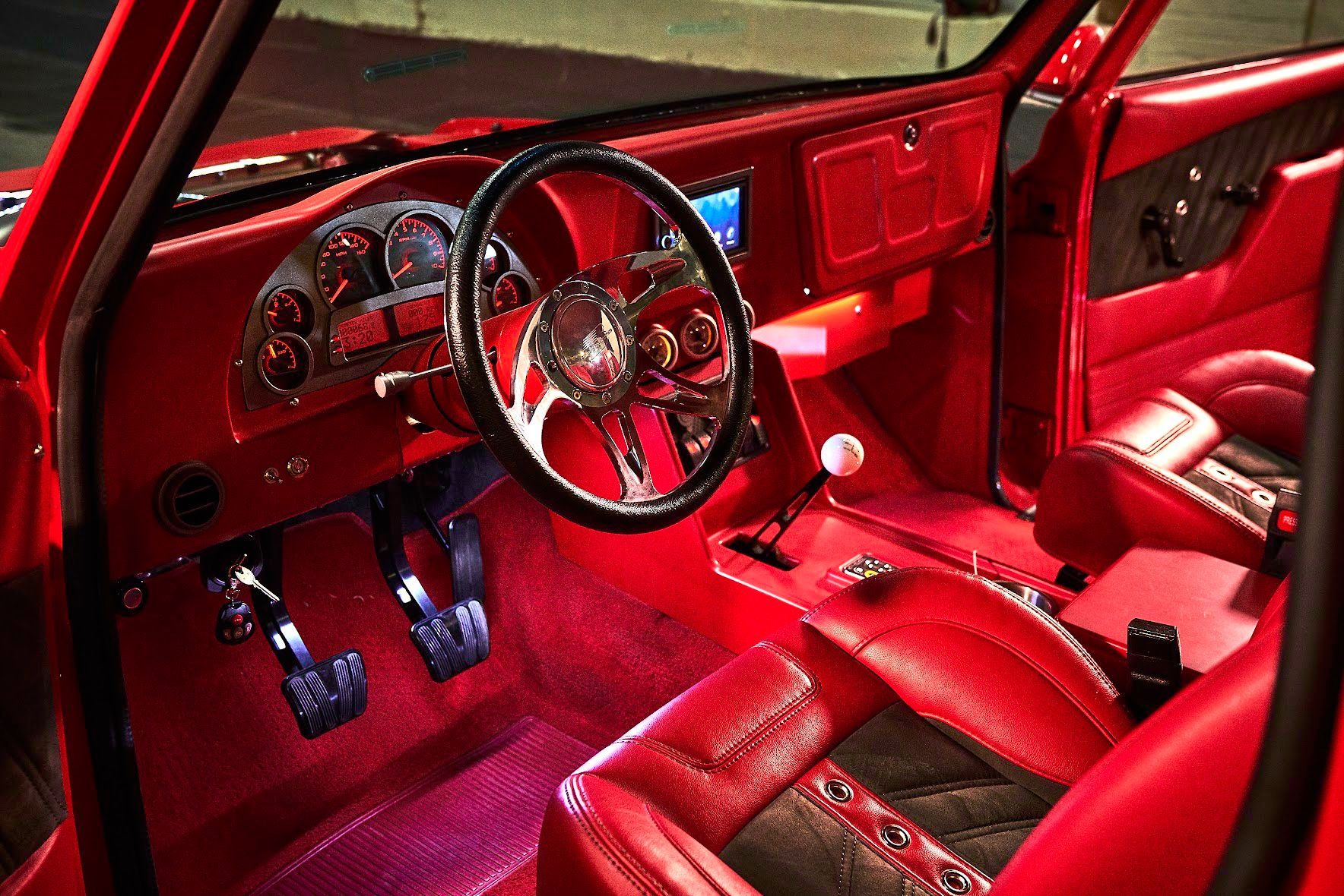 The interior of a red car with red seats and a steering wheel