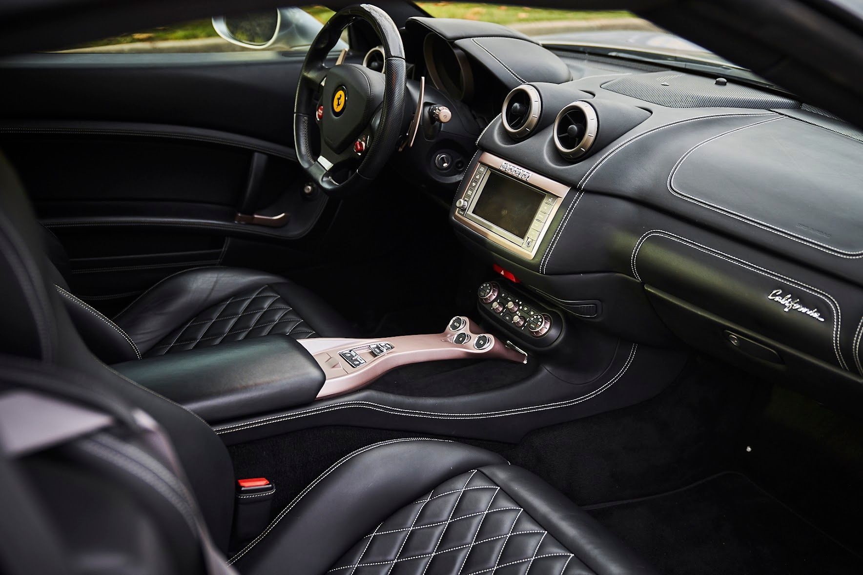 The interior of a ferrari sports car with black leather seats