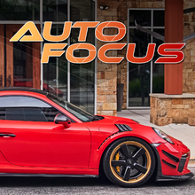 A red sports car is parked in front of a building.