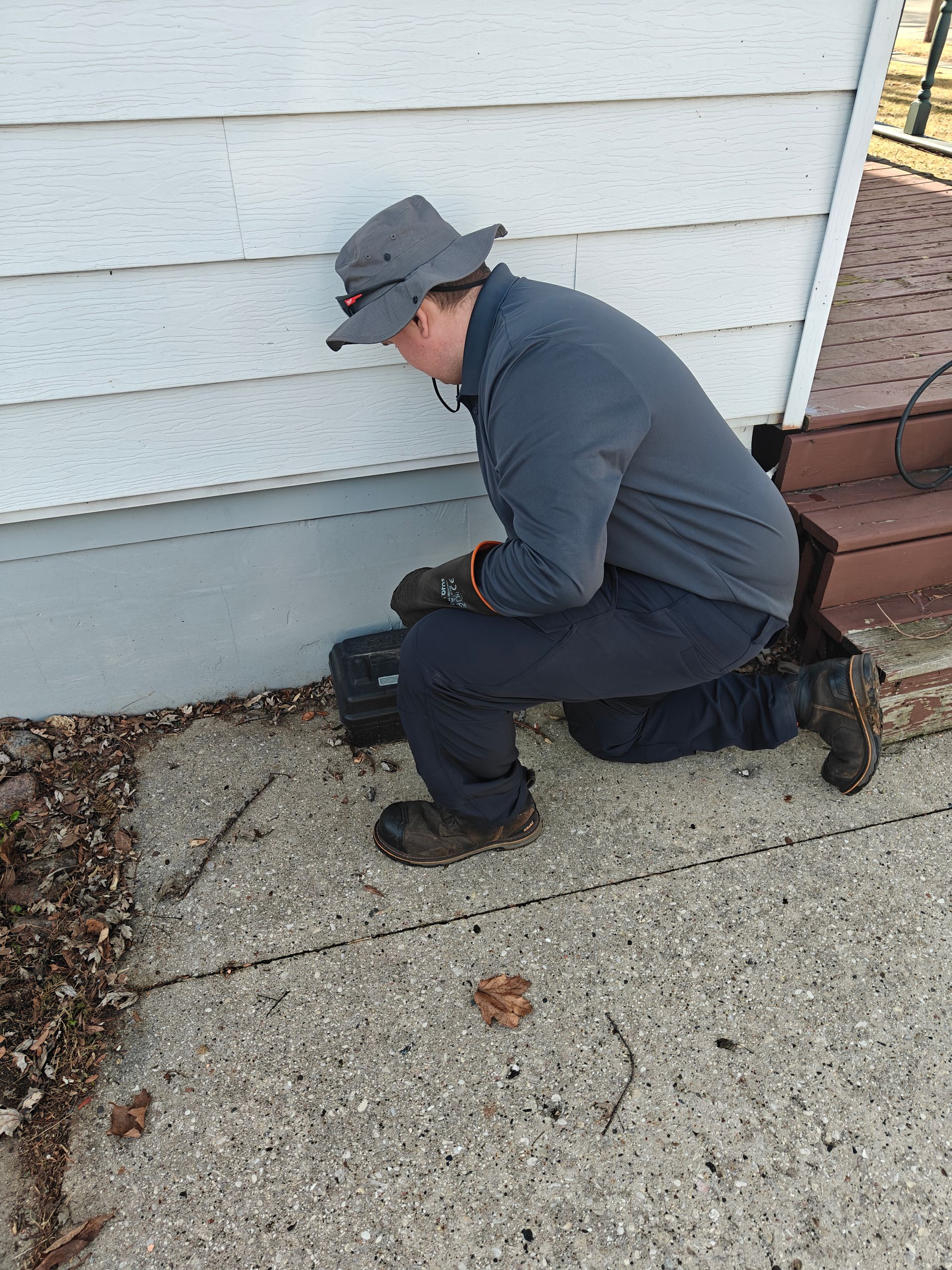 Person in hazmat suit spraying insecticide in a kitchen.