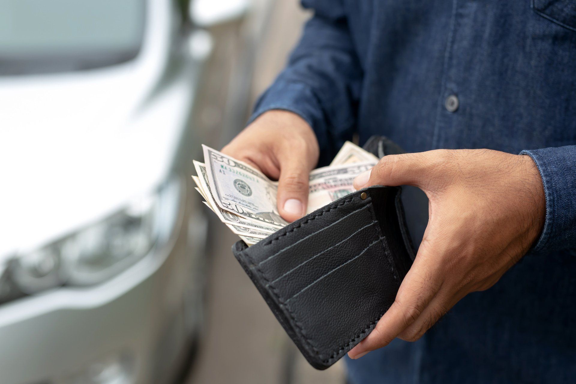 Man putting cash in wallet from selling car