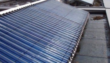 Eine Reihe blauer Solarmodule auf dem Dach eines Gebäudes.