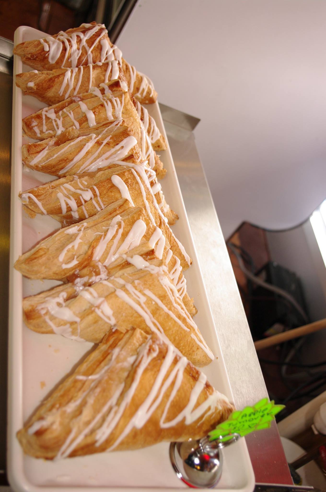 A tray of apple turnovers with icing on them