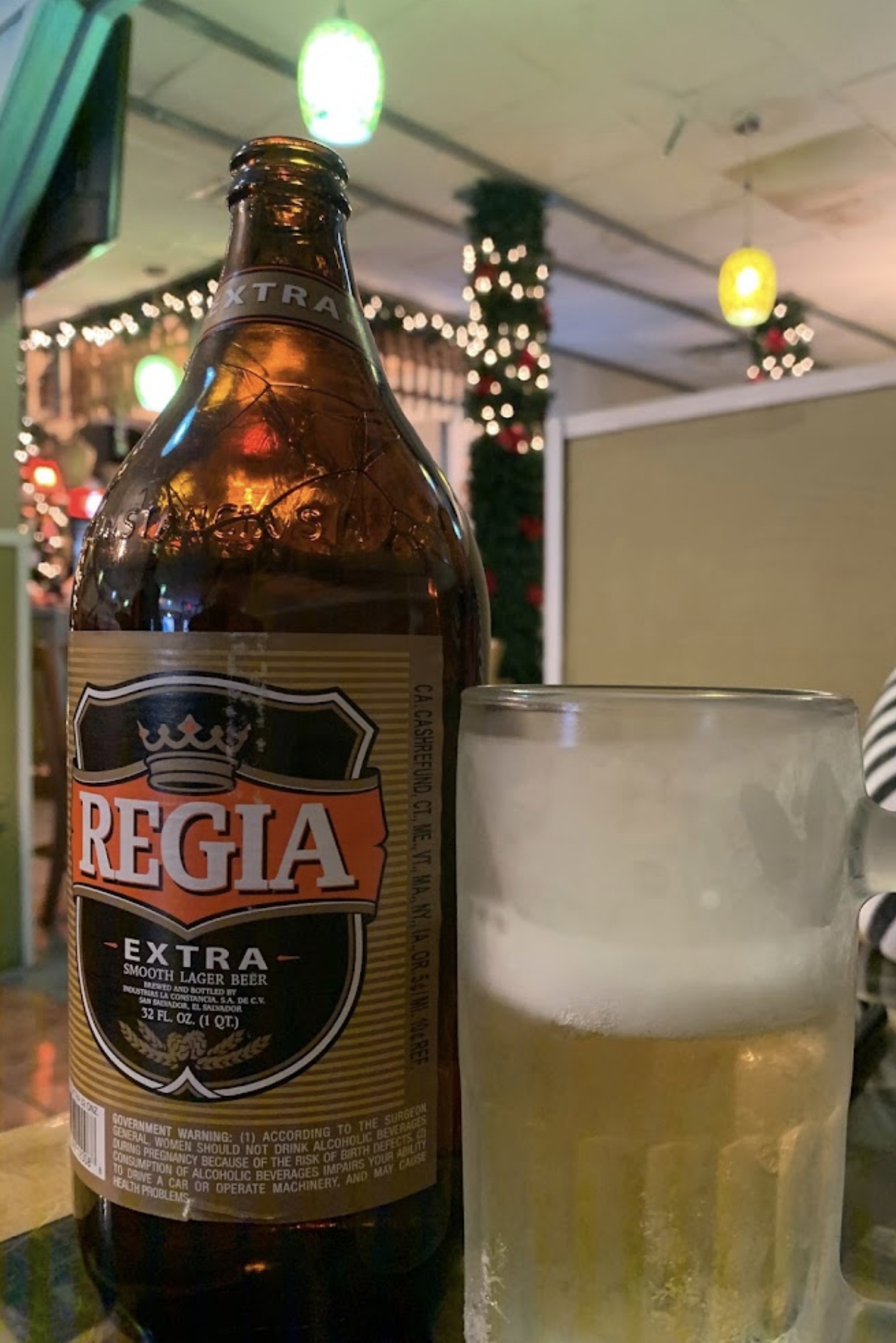 A bottle of regia extra beer next to a glass of beer