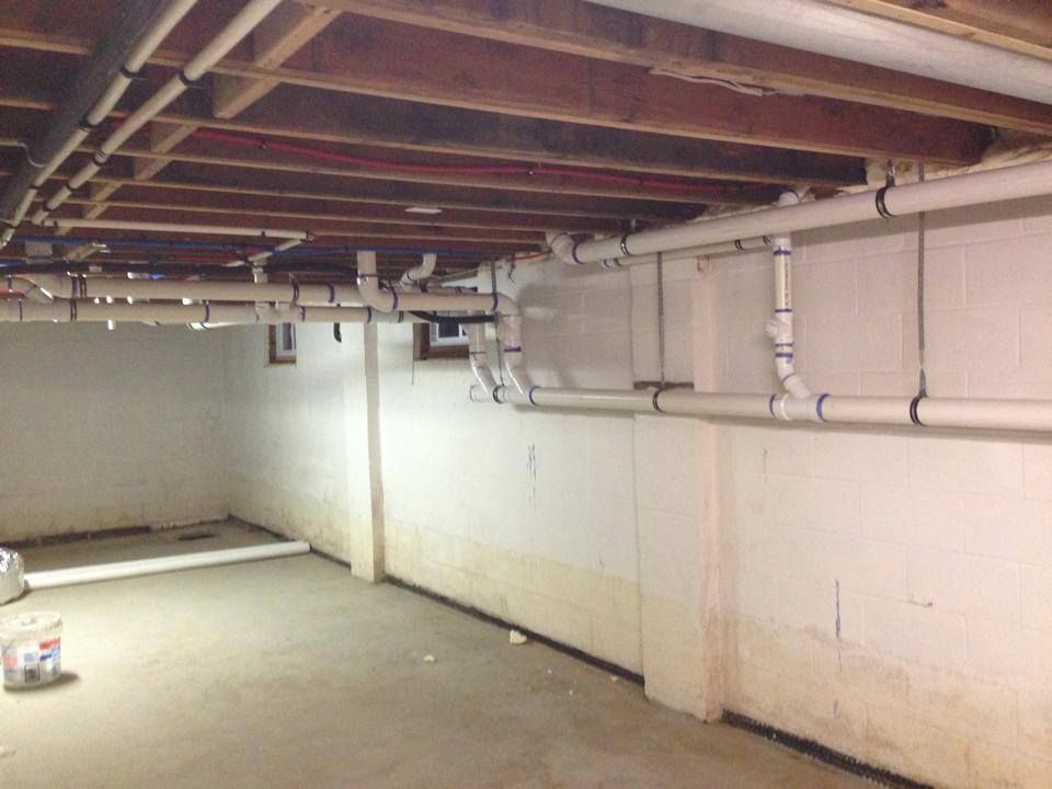 A basement with a lot of pipes going through it
