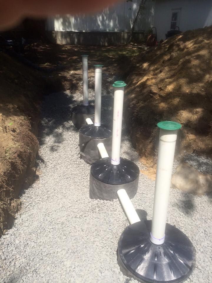 A row of pipes sitting on top of a pile of gravel.