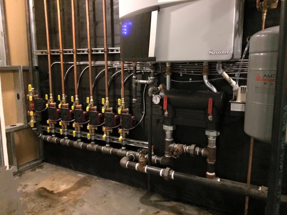 A room with a lot of pipes and valves on the wall.