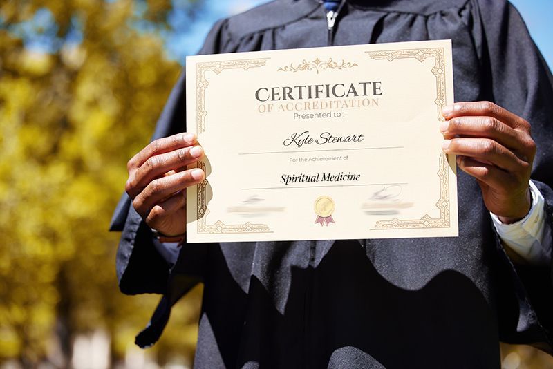 a man in a graduation cap and gown is holding a certificate in his hands .