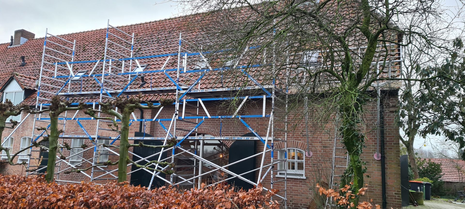 Een man houdt een moersleutel vast voor een kraan en een bordje met de tekst 'voor al je waterproblemen in huis'