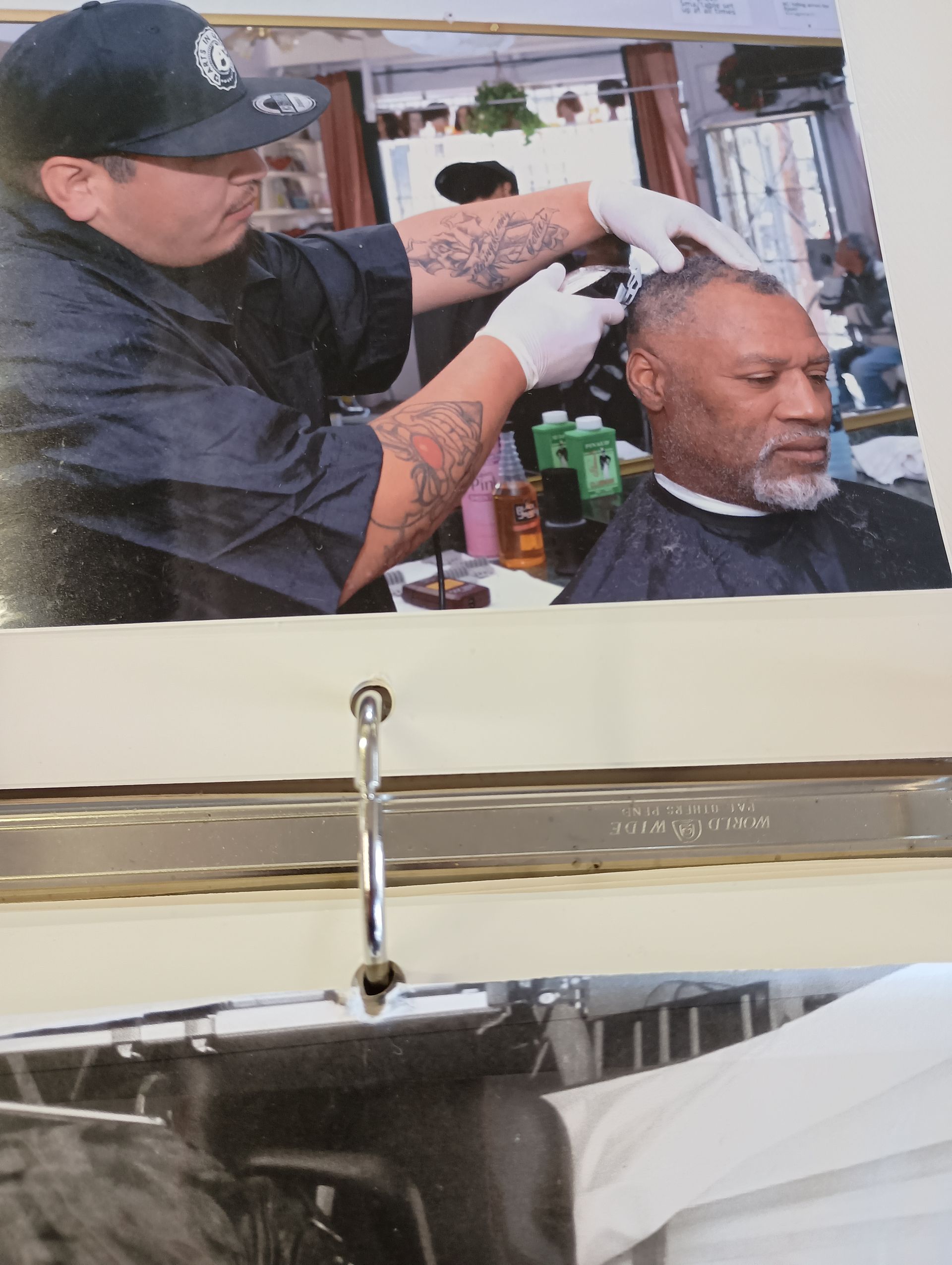 A man is getting his hair cut at a barber shop