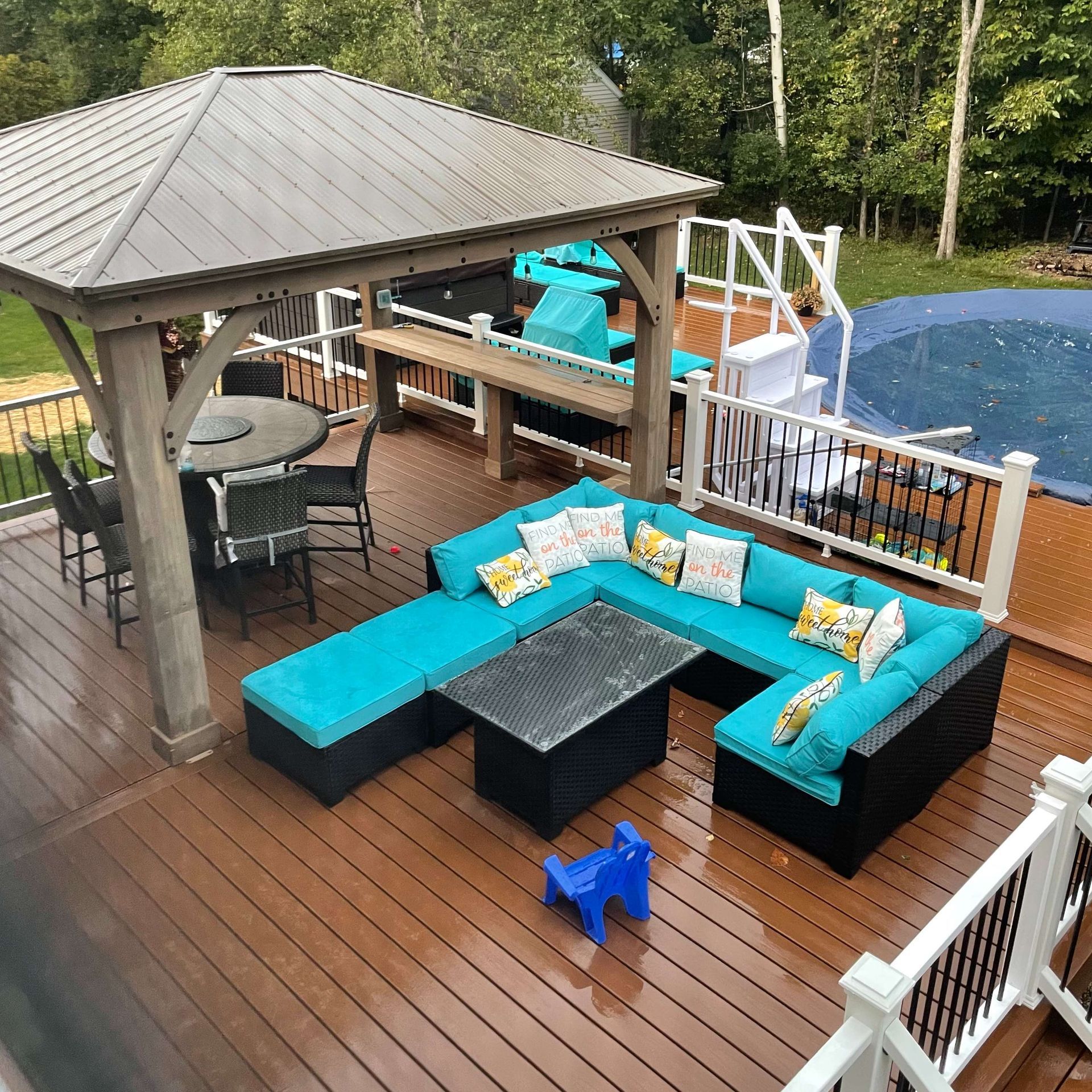 A deck with a gazebo and a sectional couch