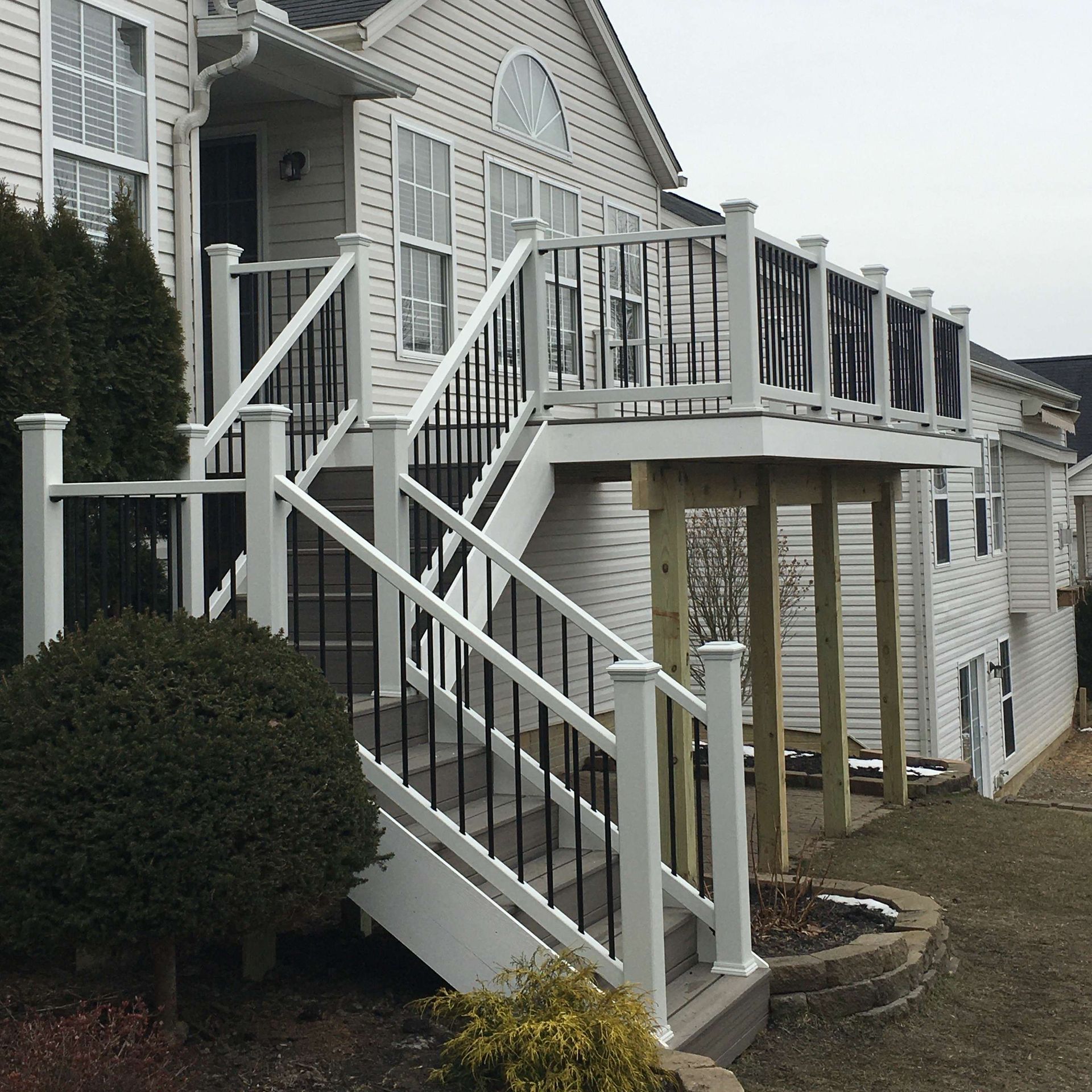 A white house with stairs leading up to a deck