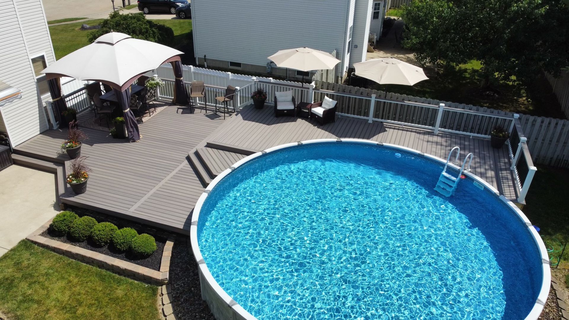 An aerial view of a swimming pool and deck in a backyard.