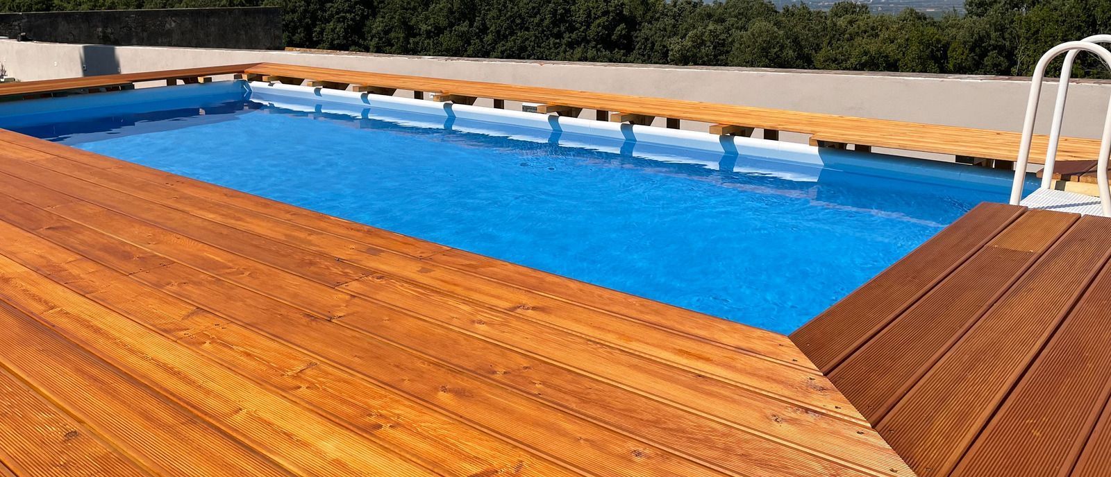 A swimming pool with a wooden deck around it.